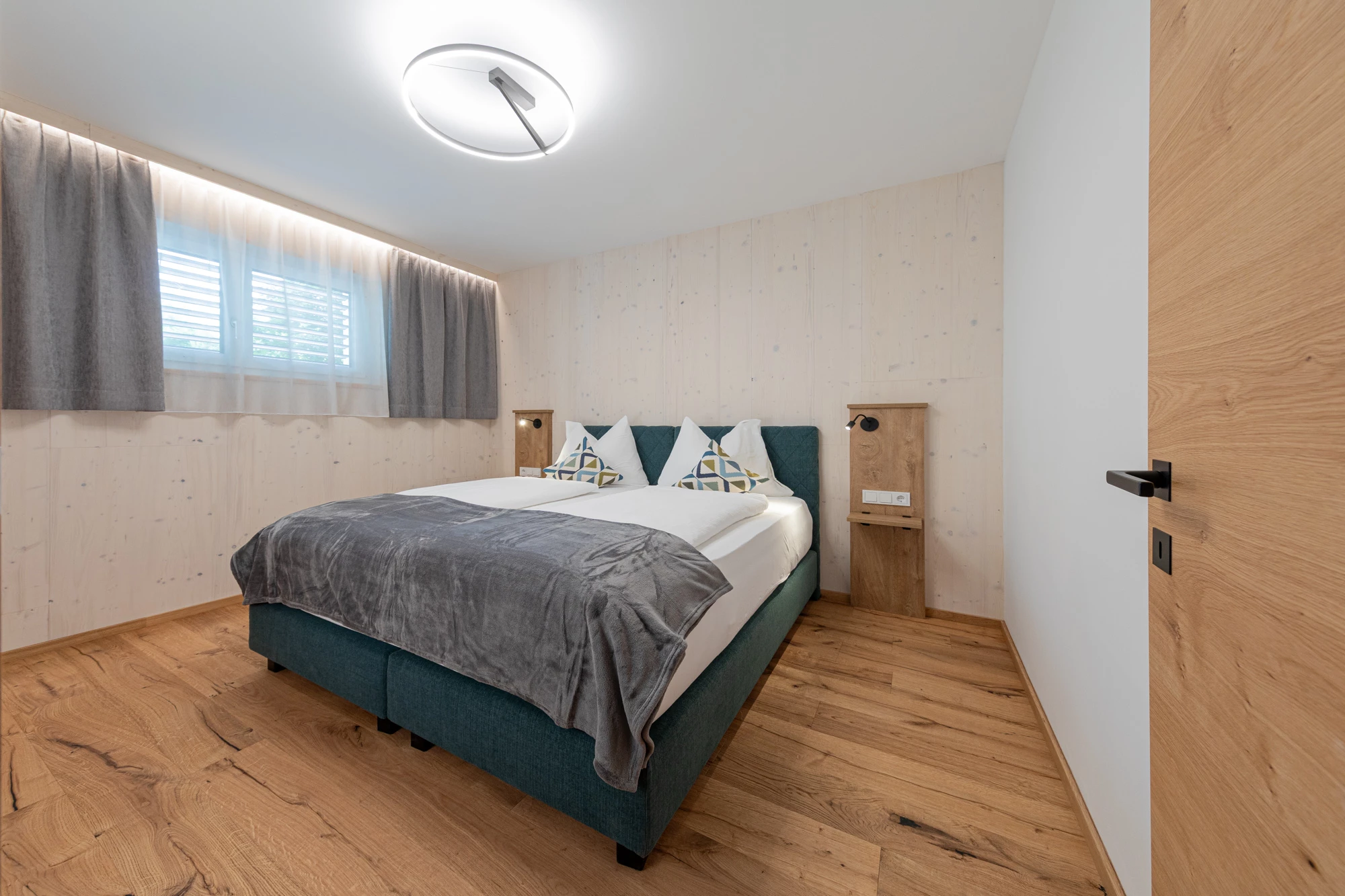 Helles Schlafzimmer in AP1 mit Doppelbett, hellen Holzwänden und Eichenboden