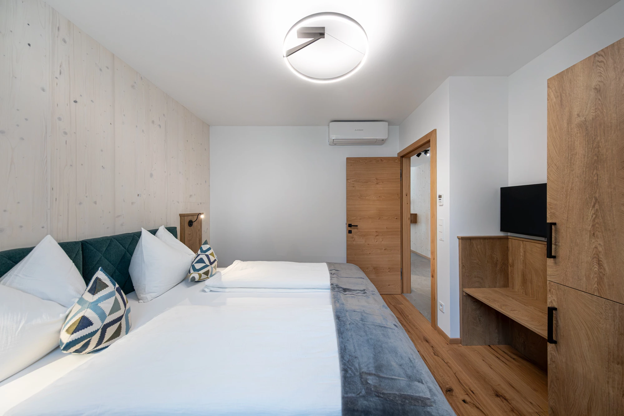 Schlafzimmer mit Doppelbett, TV und Kleiderschrank