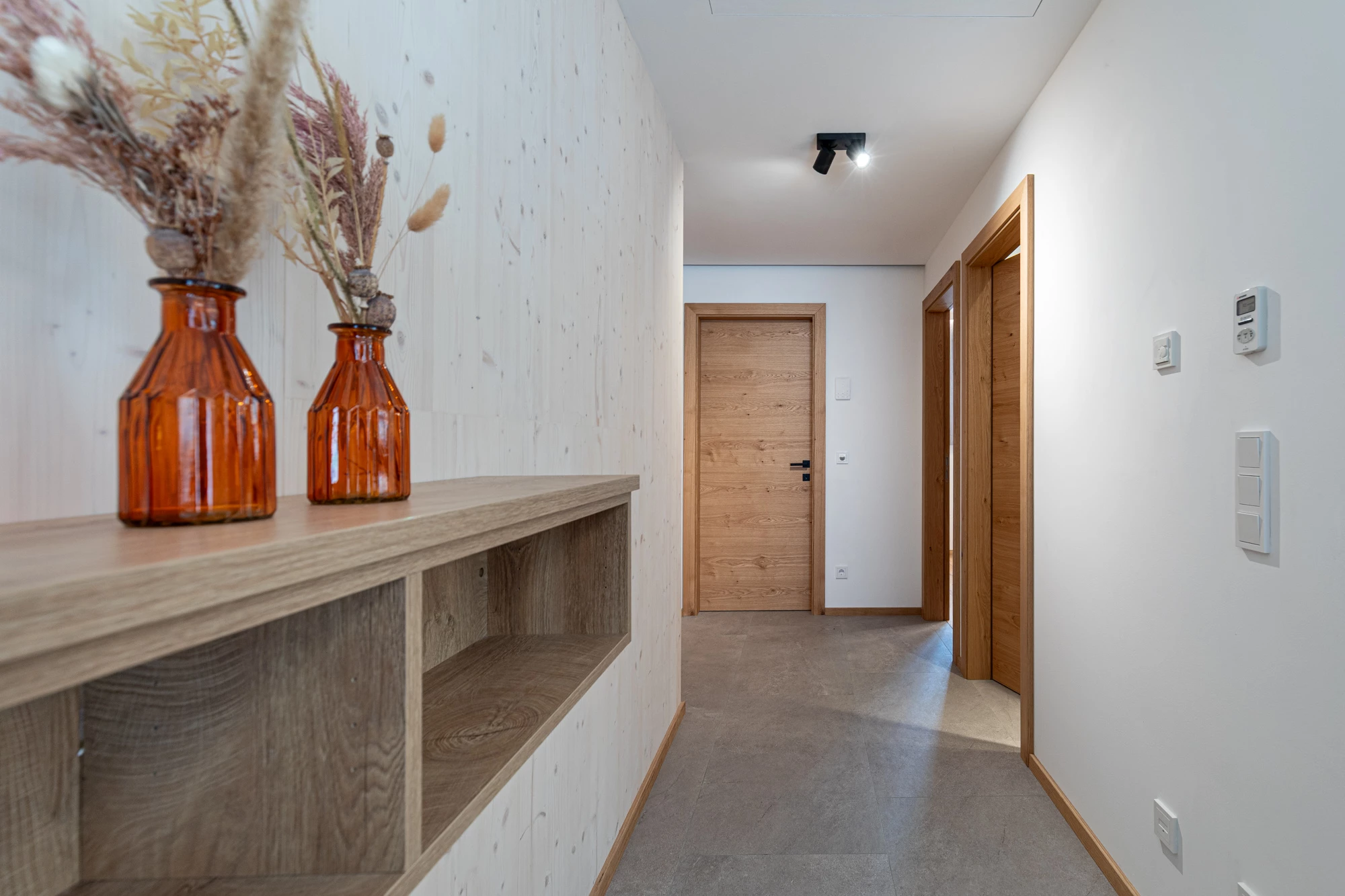 Heller Flur mit Holzablage und dekorativen Vasen