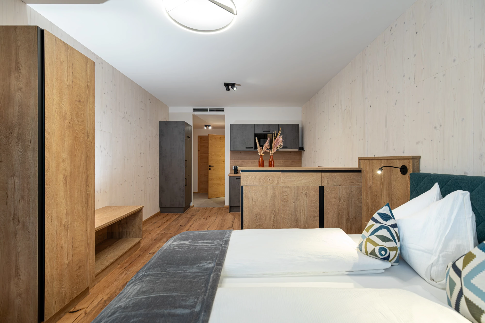 Raum mit Kleiderschrank, Sitzbank, Sideboard und Küchenzeile