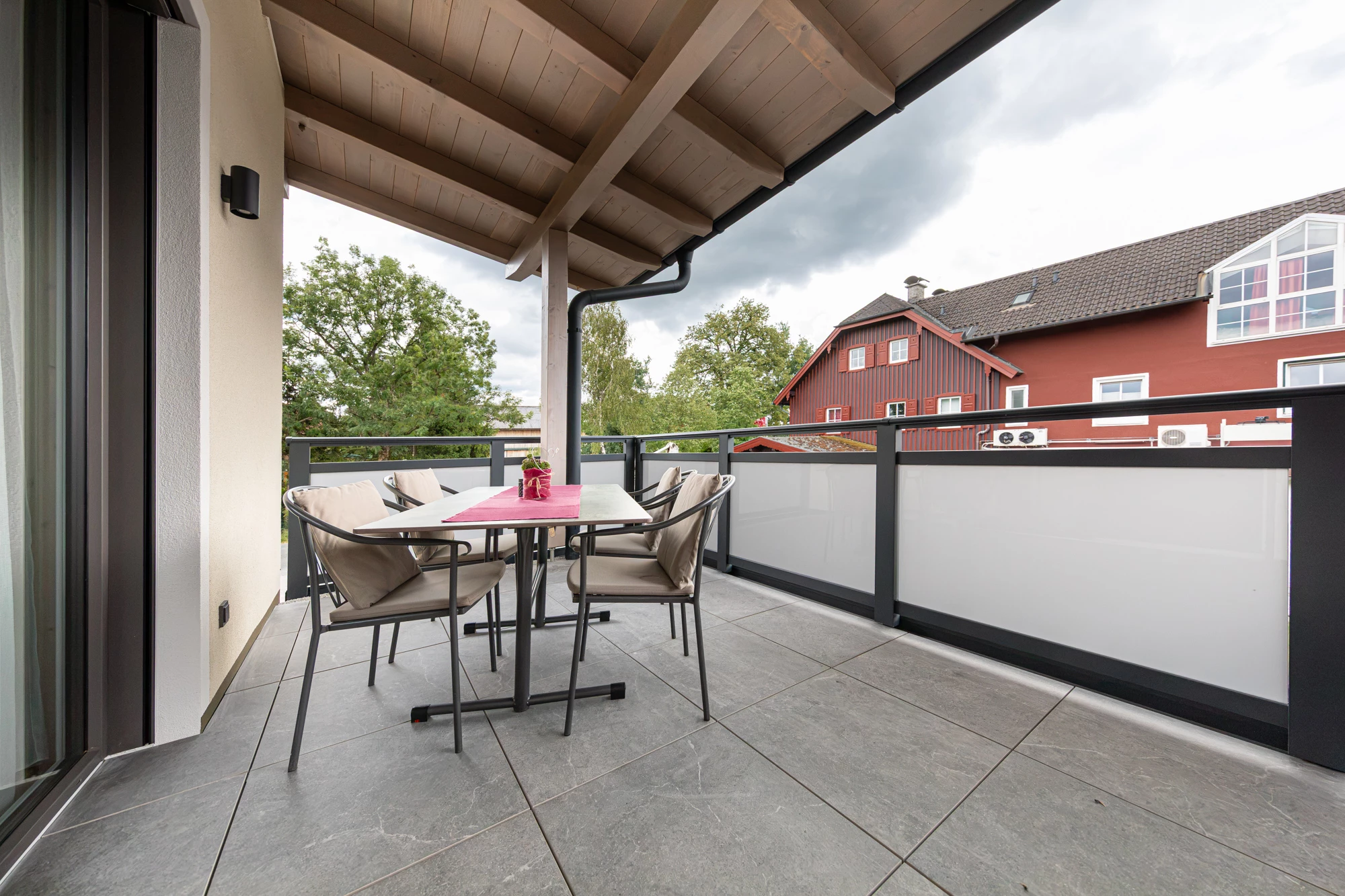 Balkon mit Sitzgruppe und Blick auf Bäume und Nachbarhäuser