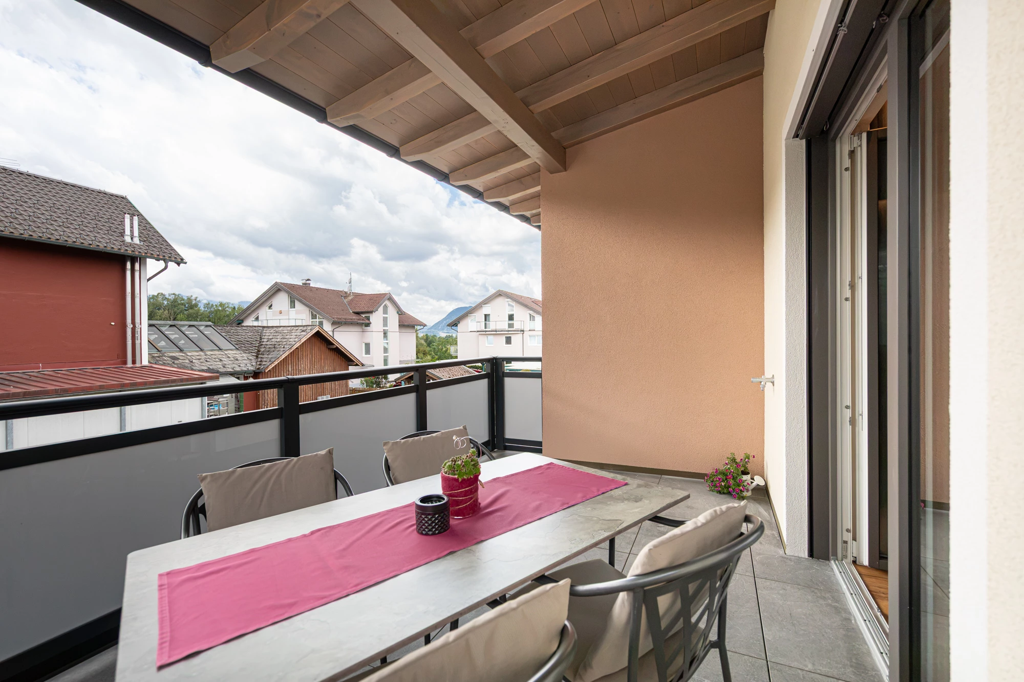 Balkontisch mit Blick über die Dächer bis zu den Bergen