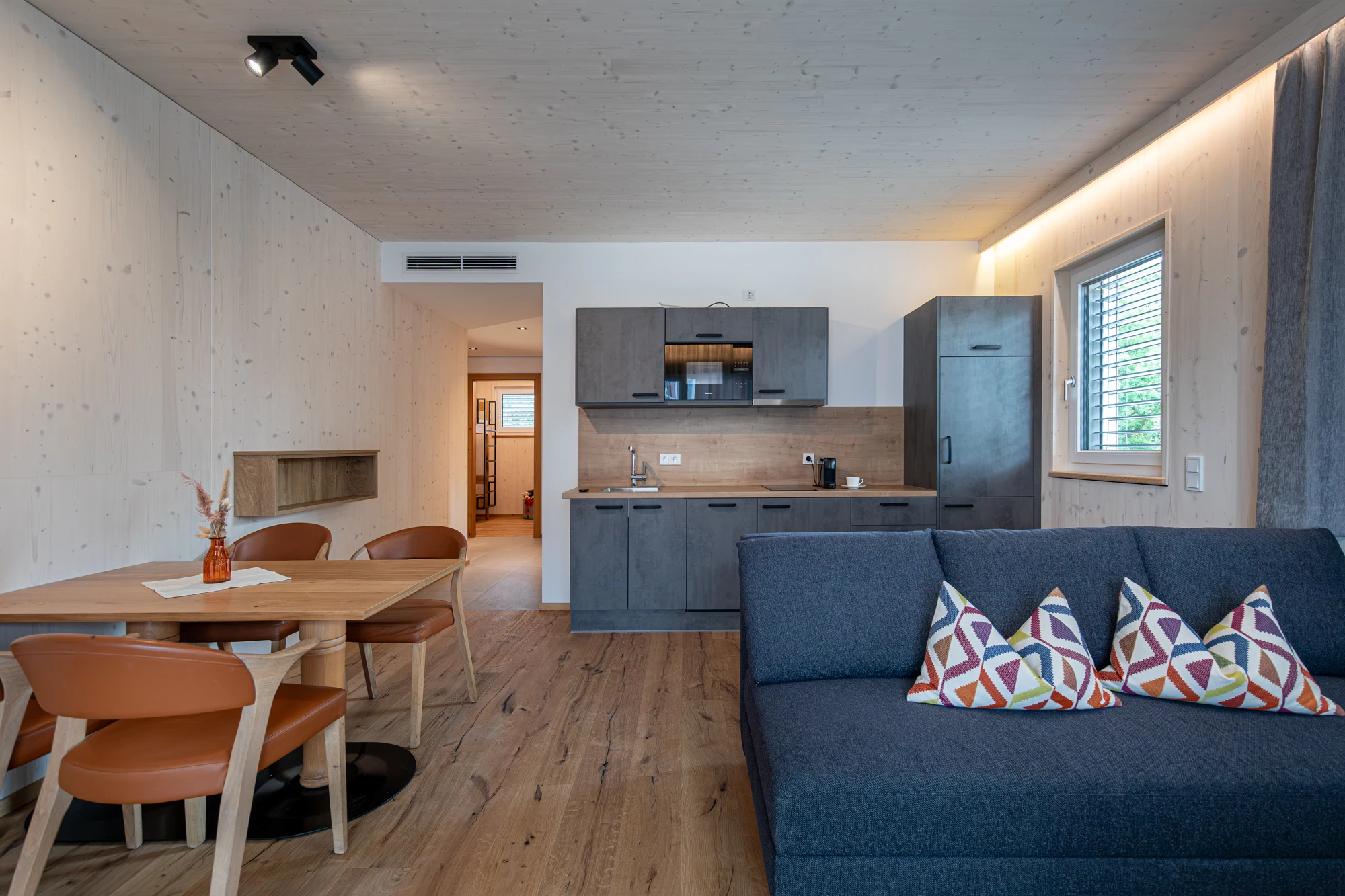 Küchenzeile und Essplatz mit Blick in das Zimmer mit Stockbett