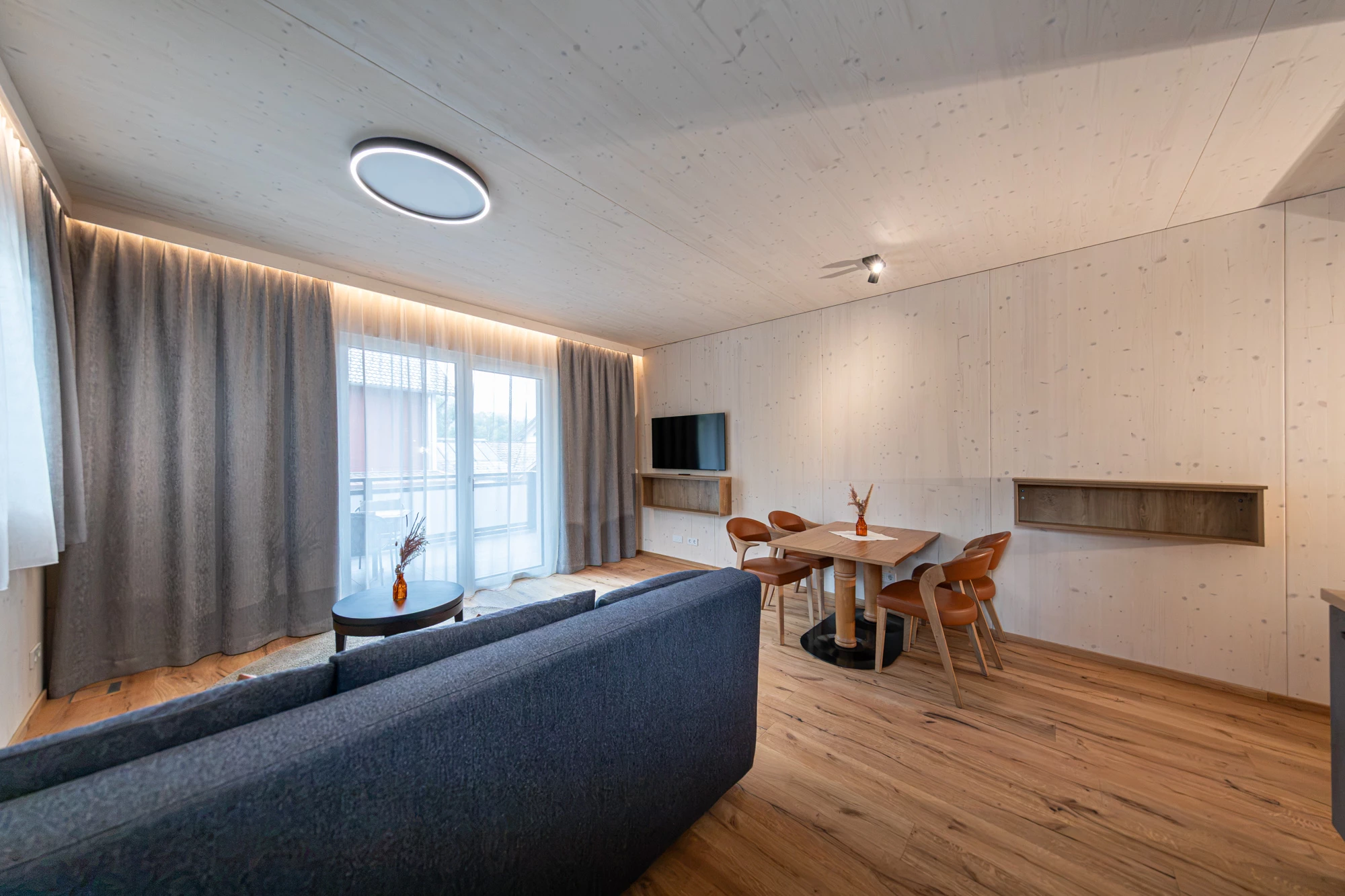 Blick vom Sofa zur Balkontür, zum TV und zum Essplatz